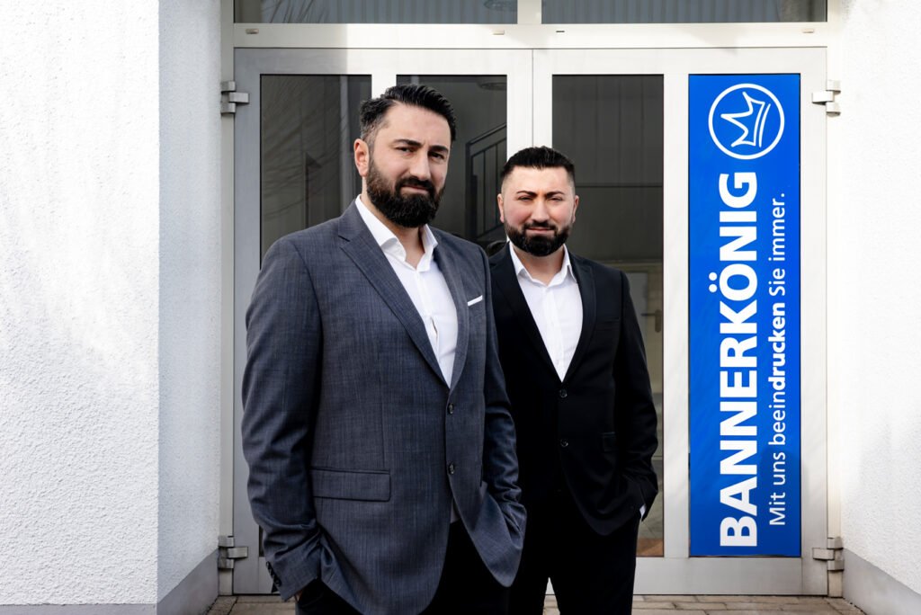 BANNERKÖNIG GmbH - Selcuk und Serkan Günes vor dem Haupteingang der Hauptsitzes in Gelsenkirchen.