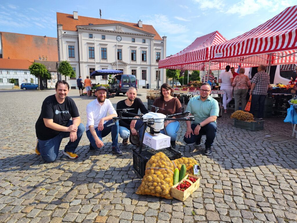 Projektteam von Stadt-Land-Drohne auf dem Marktplatz von Wusterhausen/Dosse (© Sven Juerß