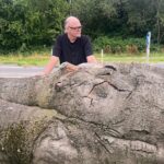 Der Kölner Künstler Bernd Reiter mit dem Baummstamm