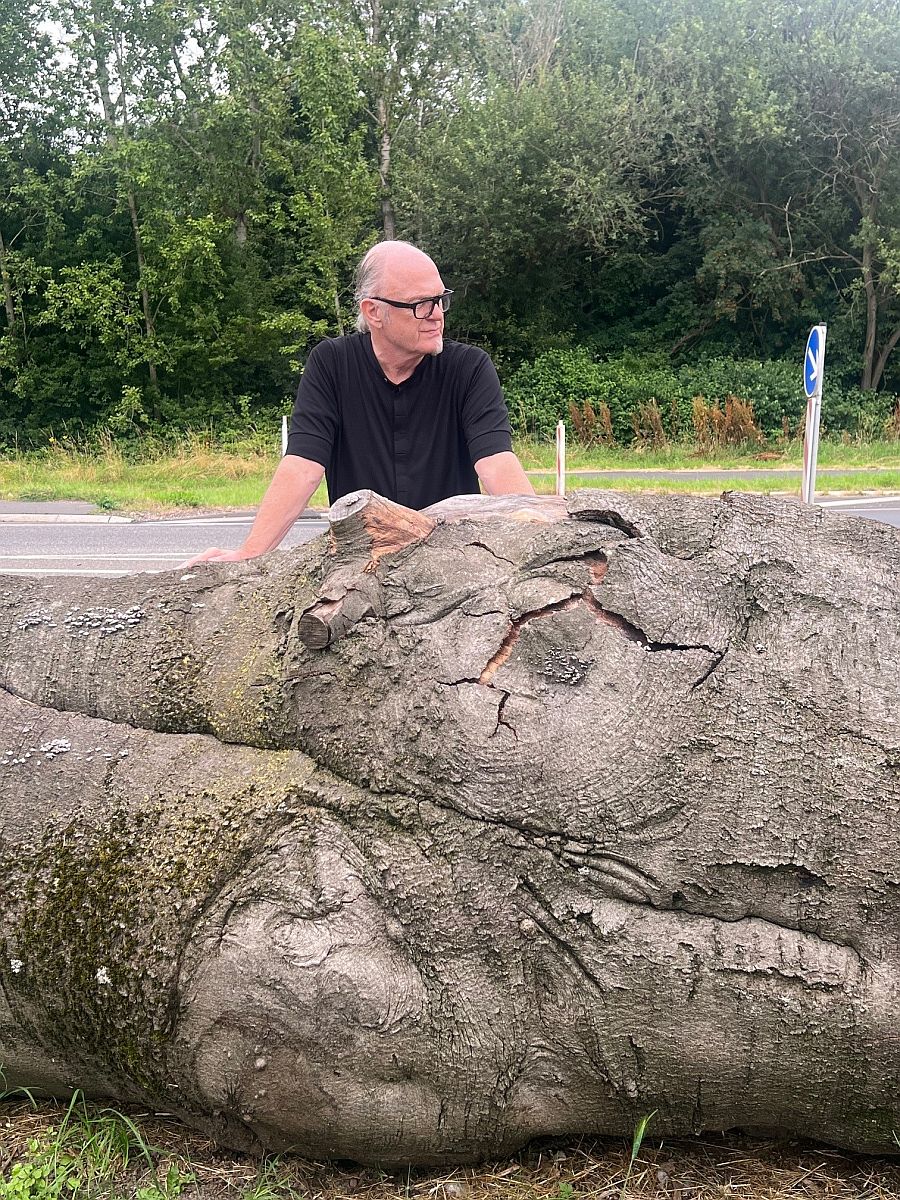 Der Kölner Künstler Bernd Reiter mit dem Baummstamm