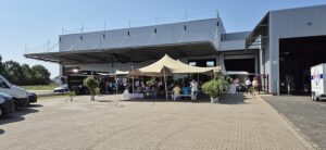 Vor der neuen Montagehalle (Hintergrund) wurde die Fertigstellung des Rohbaus ausgiebig gefeiert. (Die Bildrechte liegen bei dem Verfasser der Mitteilung.)